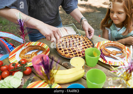 Mother serving food for her daughter at picnic, Munich, Bavaria, Germany Stock Photo