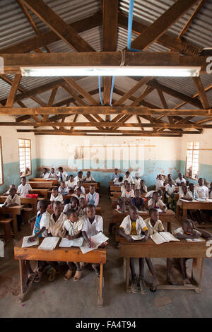 Students attend school in a classroom lit by overhead lighting at Hogoro Primary School in Hogoro village, Dodoma Region, Tanzan Stock Photo
