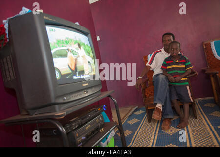 A family watches a DVD in their home in the village of Hogoro, Dodoma Region, Tanzania. Stock Photo