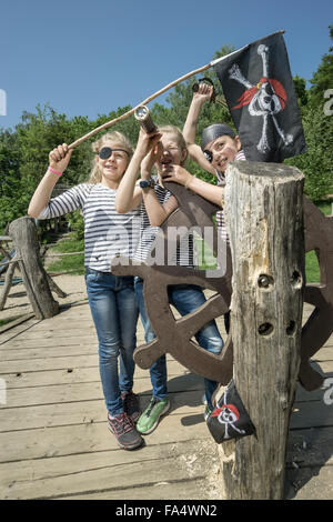 Three girls playing on a pirate ship in adventure playground, Bavaria, Germany Stock Photo