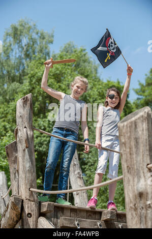 Two girls playing on pirate ship in adventure playground, Bavaria, Germany Stock Photo
