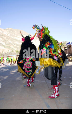 Dancers in traditional costumes and masks, spectators, musicians in a parade at the 500 year celebration of Luribay, Bolivia Stock Photo