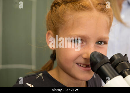Close-up of a school girl smiling with microscope, Fürstenfeldbruck, Bavaria, Germany Stock Photo