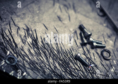 close up image of some screws on a scratched metal surface. Stock Photo