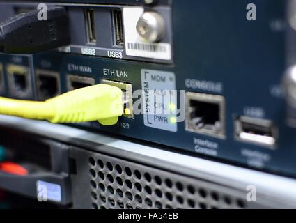 Yellow networking patch cable plug to the ethernet RJ45 port in server. Green led lights. Stock Photo