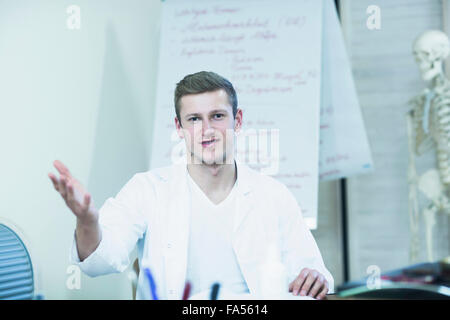 Portrait of a young doctor explaining about skeleton in his office, Freiburg Im Breisgau, Baden-Württemberg, Germany Stock Photo