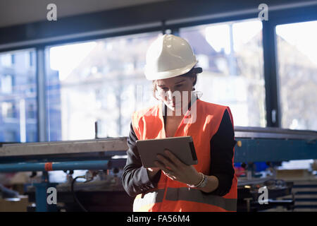 Female engineer using a digital tablet in an industrial plant, Freiburg Im Breisgau, Baden-Württemberg, Germany Stock Photo