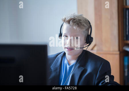 Boy imitating a customer care representative, Freiburg im Breisgau, Baden-Württemberg, Germany Stock Photo