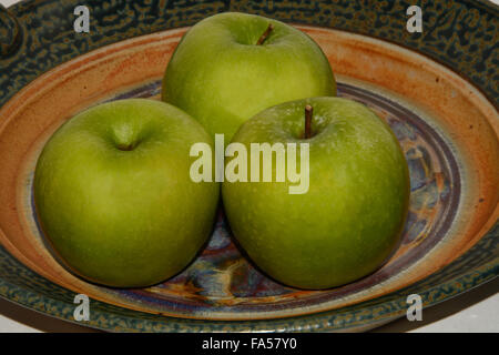 Three Granny Smith Apples on Ceramic plate Stock Photo