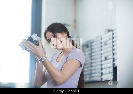 Female technician examining electrical component in an industrial plant, Freiburg Im Breisgau, Baden-Württemberg, Germany Stock Photo