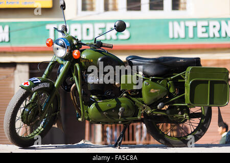 A green Enfield Bullet 350, a cult classic British motorcycle brand, is parked on a Gangtok street Stock Photo