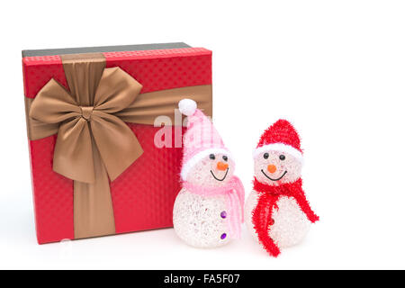 two smiling toy christmas snowman and a present box on white background Stock Photo