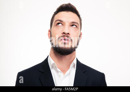 Portrait of pensive attractive bearded young man in formalwear thinking and looking up over white background Stock Photo