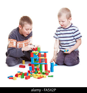 Two boys playing together with many building bricks Stock Photo