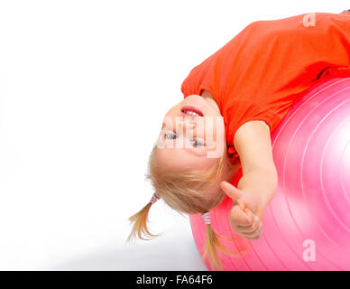 Cute little girl lying on pink ball Stock Photo