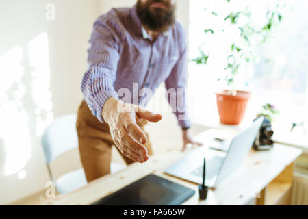 Beard business man with arm extended to handshake Stock Photo