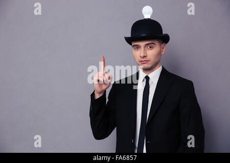 Portrait of a young businessman having idea over gray background Stock Photo