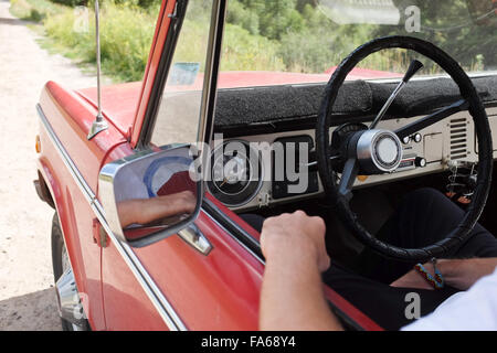 Man sitting in car with arm out of window Stock Photo