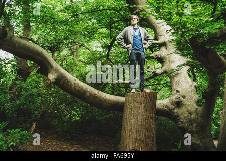 A young man standing on a tall tree stump Stock Photo