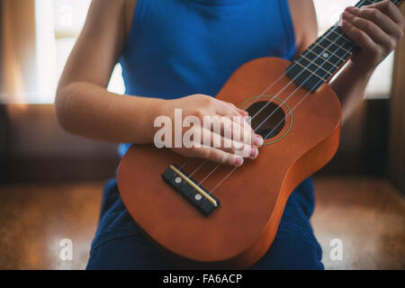 Girl playing a ukulele Stock Photo