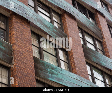 Close up of the exterior of the Chelsea Market building in New York, with red bricks and copper facade details. Stock Photo