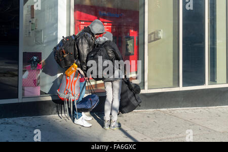 Backpackers in winter in New York City using the online map on a smartphone Stock Photo