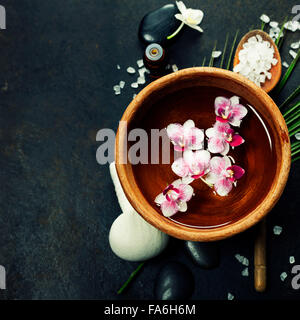 Close up of flowers floating in bowl of water and SPA setting Stock Photo