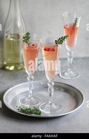 Pomegranate champagne in glasses with fresh thyme decoration Stock Photo