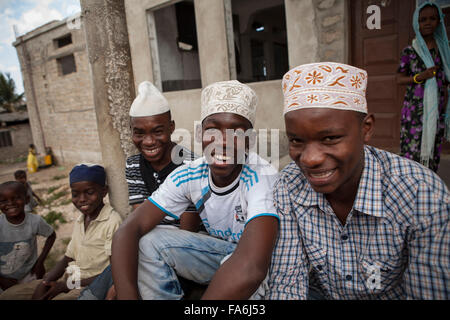 Young men sit on the steps of the Raudhwa Mosque in Zanzibar, Tanzania. Stock Photo