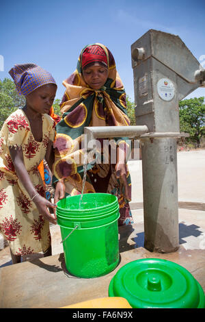 Children draw clean water from a borehole in Mecupes village, Northern Mozambique. Stock Photo