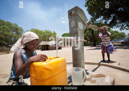 Lurdes Favrito (left) draws clean water from a borehole in Mecupes village, Mozambique. The Millennium Challenge Corporation has Stock Photo