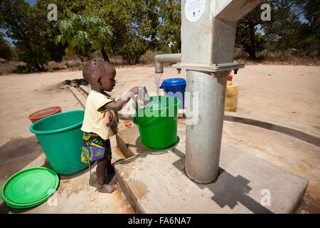 Children draw clean water from a borehole in Mecupes village, Northern Mozambique. Stock Photo