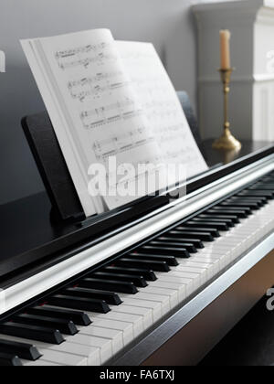 Digital piano keyboard with music scores in a living room interior Stock Photo