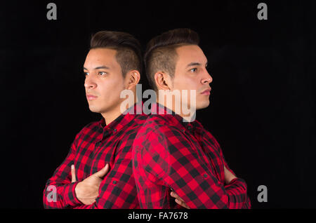 Hispanic male wearing red black squared shirt from profile angle, reflecive effect used for an artistic presentation Stock Photo