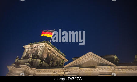 Berlin, Germany. 23rd Dec, 2015. A German national flag flies on the Reichstag parliamentary building during blue hour in Berlin, Germany, 23 December 2015. Photo: LUKAS SCHULZE/dpa/Alamy Live News Stock Photo