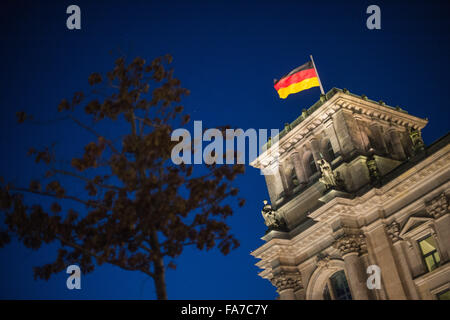 Berlin, Germany. 23rd Dec, 2015. A German national flag flies on the Reichstag parliamentary building during blue hour in Berlin, Germany, 23 December 2015. Photo: LUKAS SCHULZE/dpa/Alamy Live News Stock Photo