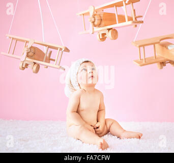 Little girl playing wooden toy planes Stock Photo