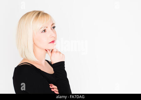 Decision making - difficult life choices and options : A young slim blonde blond haired woman girl, thinking, pondering, thoughtful, UK Stock Photo