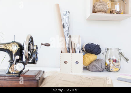 Detail of a sewing machine and knitting wool roll A house combining modern minimalist style with display of traditional objects used in every day life. Stock Photo