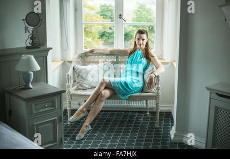 Pretty brunette lady sitting on the wicker bench Stock Photo