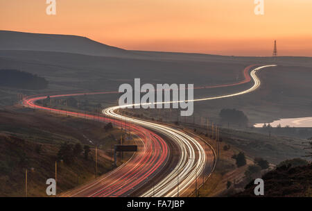 M62 motorway weaving through the Pennines with long exposure light trails. Windy Hill mast in the distance. Stock Photo