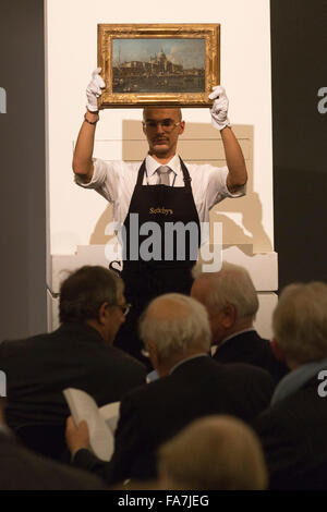 Handler presenting a painting. The auction for paintings from the Old Master & British Paintings Evening Sale takes place at Sotheby's New Bond Street, London. Stock Photo