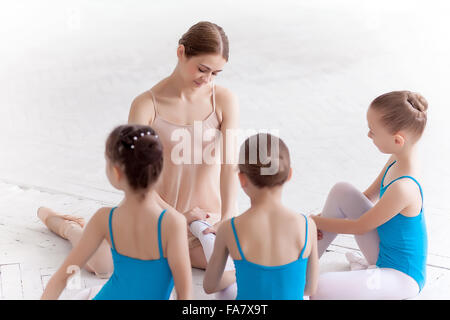 Three little ballerinas dancing with personal ballet teacher in dance studio Stock Photo