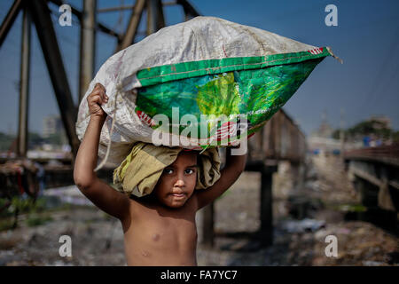 Dec. 23, 2015 - Dhaka, Bangladesh - SHIHAB is a 6 year old boy who collects materials from garbage. He sales those materials to earn little money. His mother also do the same in Dhaka. After collecting plastic materials from garbage SHIHAB is now taking them to local dealer to sell. (Credit Image: © Mohammad Ponir Hossain via ZUMA Wire) Stock Photo