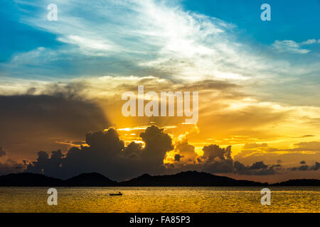 golden light of the sun rising and shining through the clouds Stock Photo