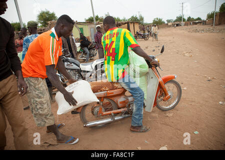 Small farmers receive sacks of seed and fertilizer at a distribution in Banfora Department, Burkina Faso. Stock Photo