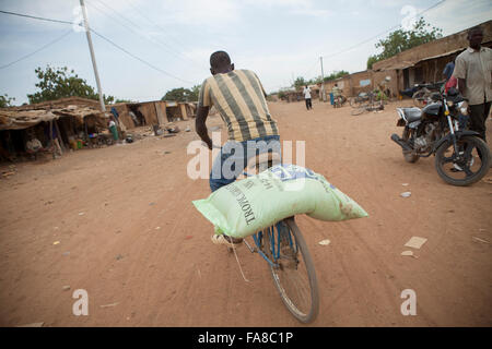 Small farmers receive sacks of seed and fertilizer at a distribution in Banfora Department, Burkina Faso. Stock Photo