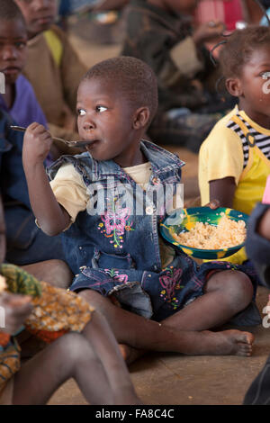 Kindergartners eat lunch at Kouka Primary School in Kouka Department, Burkina Faso. Stock Photo