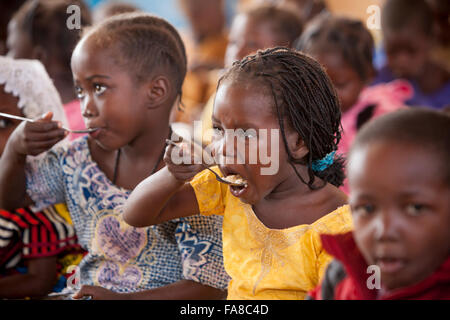 Kindergartners eat lunch at Kouka Primary School in Kouka Department, Burkina Faso. Stock Photo