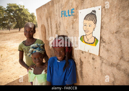 Girls stand outside the girls' toilet at a primary school in Banwa Province, Burkina Faso, West Africa. Stock Photo